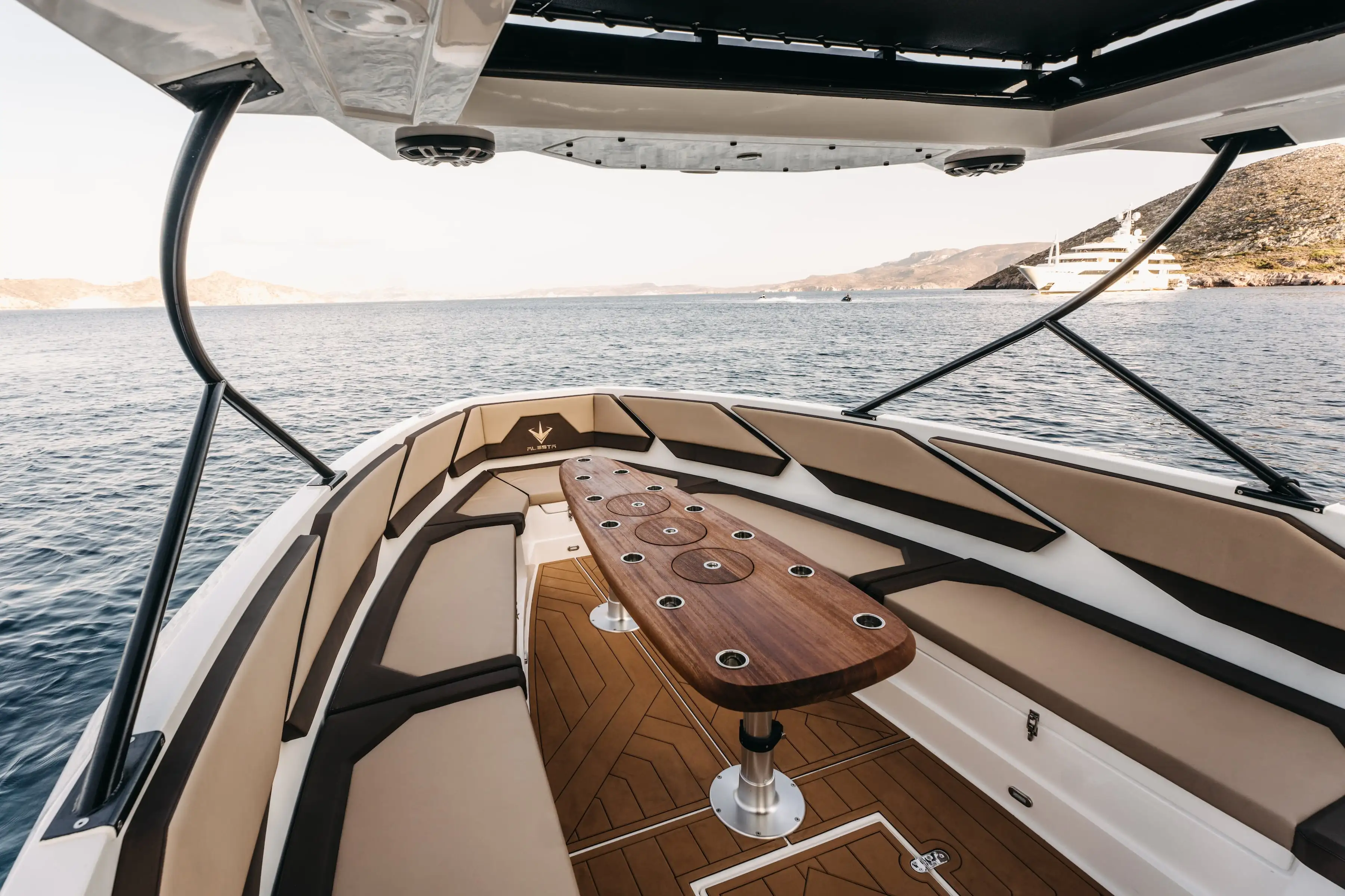 Bow lounge with beige cushions and teak table on the Navy Blue Raptor
