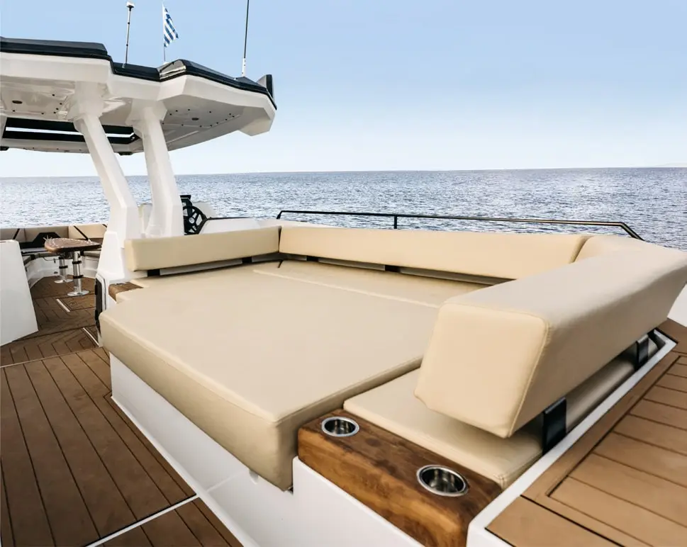 Aft deck sun pad with beige cushions and teak flooring on the Navy Blue Raptor