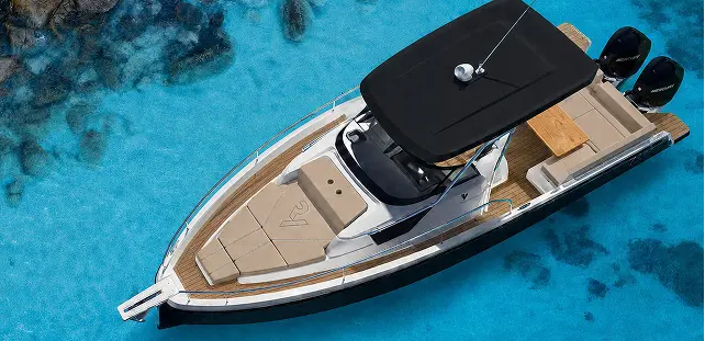 Overhead view of Ryck luxury open-yacht by Navy Blue over clear turquoise water, black hardtop and twin outboards
