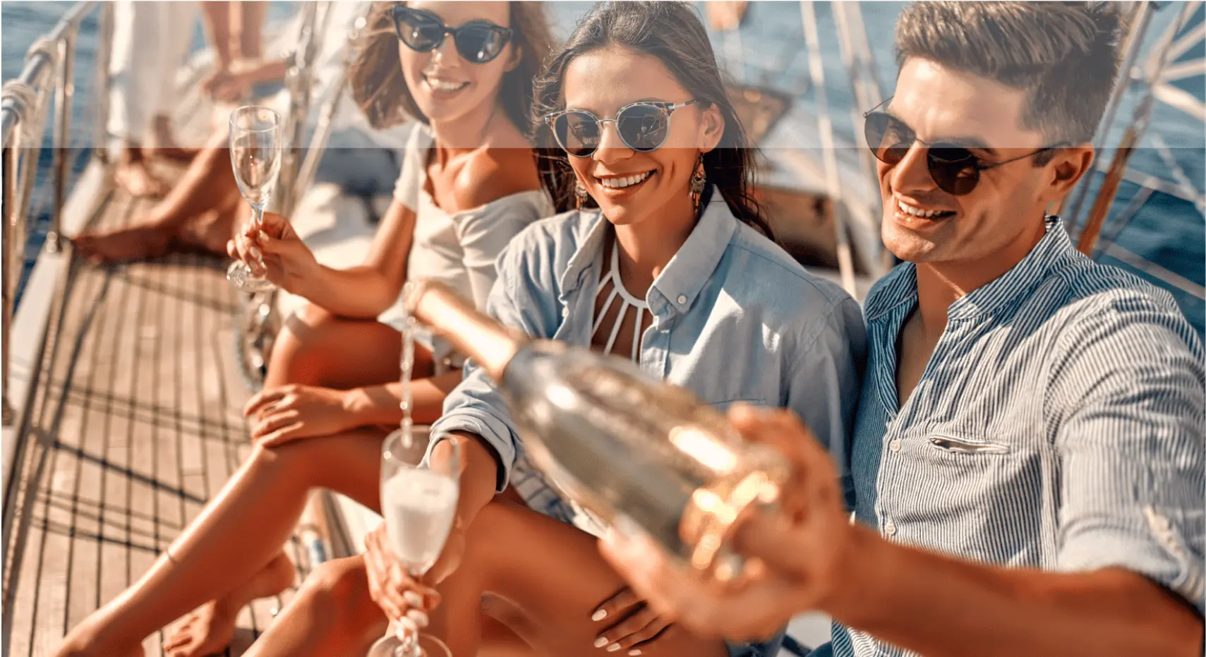 Guests enjoying open bar with champagne on a yacht deck during a cruise in Milos
