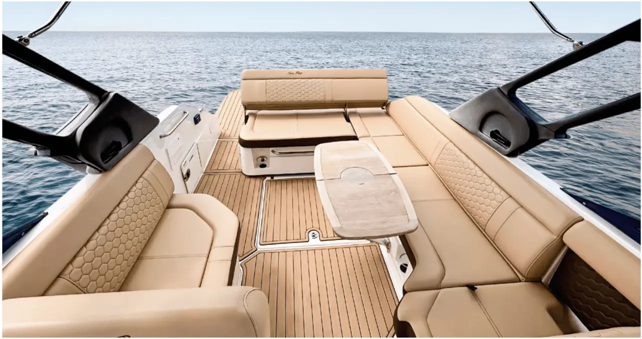 Area pranzo in teak e sedute lounge imbottite a bordo dell’open yacht di lusso Navy Blue Sea Ray