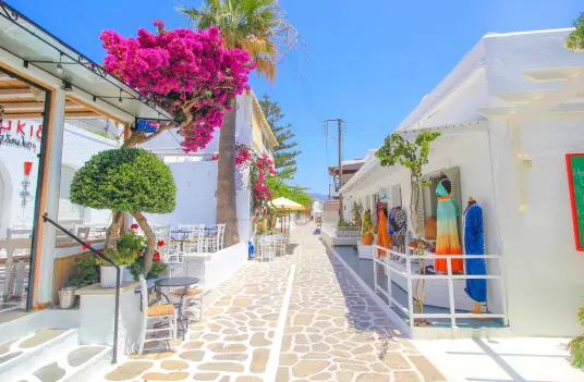 The whitewashed main street of Antiparos town, lined with shops, cafes, and bright bougainvillea