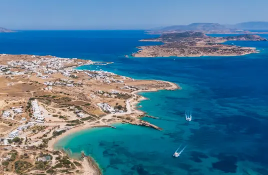 Aerial view of the Koufonisia coastline, with pale beaches, a low village, and deep blue water