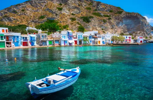 White volcanic rock formations rising from turquoise Aegean water off the coast of Milos, by Navy Blue