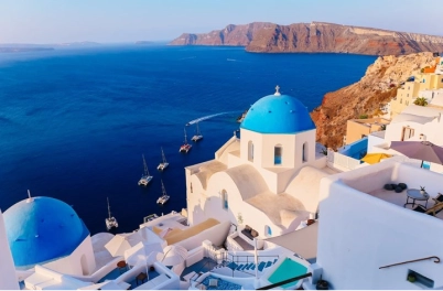 Whitewashed cliffside village in Santorini overlooking the volcanic caldera and Aegean Sea, by Navy Blue