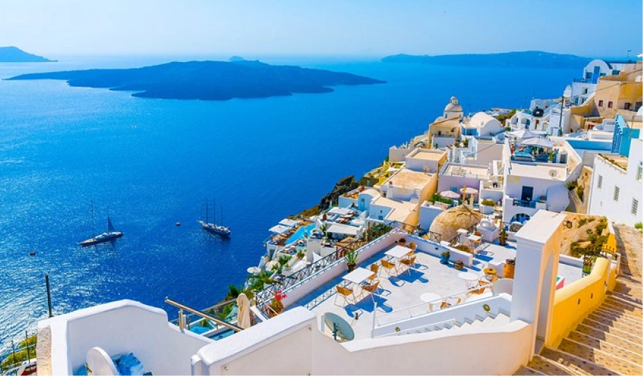 Sunset over Oia village in Santorini, with whitewashed buildings and blue domes overlooking the Aegean caldera, by Navy Blue