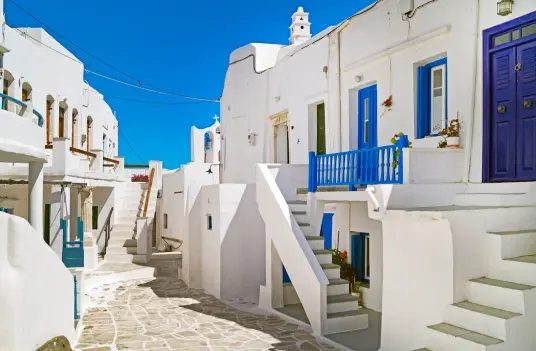 Kastro, the medieval hilltop village on Sifnos, with whitewashed walls, blue doors, and stone alleyways, by Navy Blue.