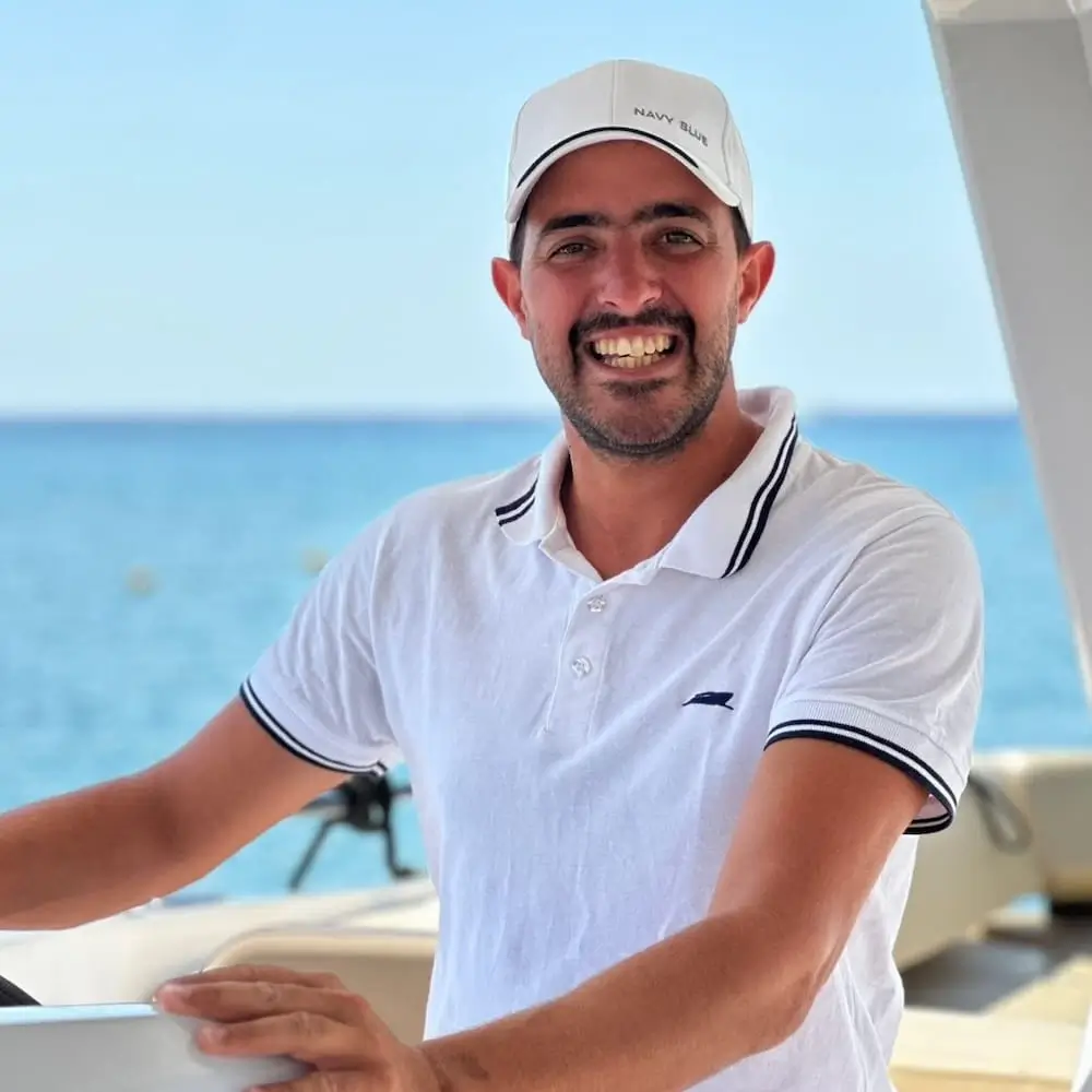 Alexandros Mitropoulos, Navy Blue captain, on deck during a cruise in the Cyclades near Milos